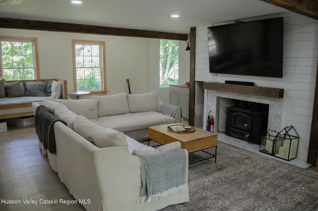 a living room with furniture a flat screen tv and a fireplace