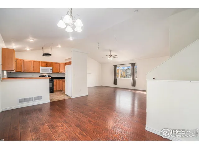 a view of a kitchen with a sink wooden cabinets and a refrigerator