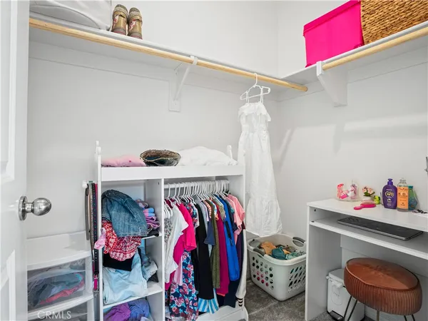 a view of walk in closet and clothes