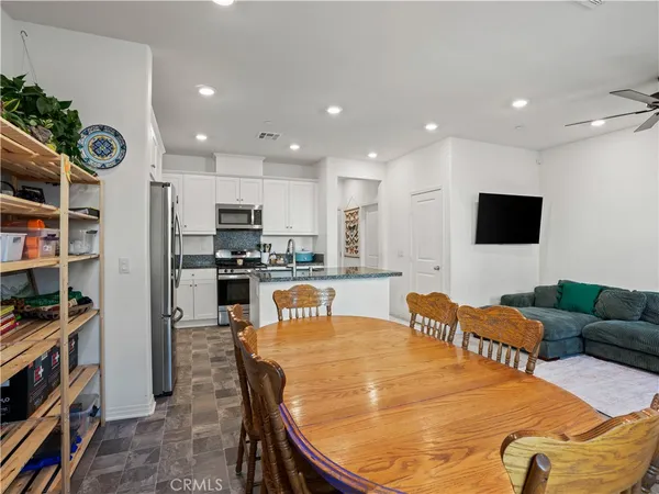 a large kitchen with stainless steel appliances granite countertop a refrigerator and a stove top oven with wooden floor