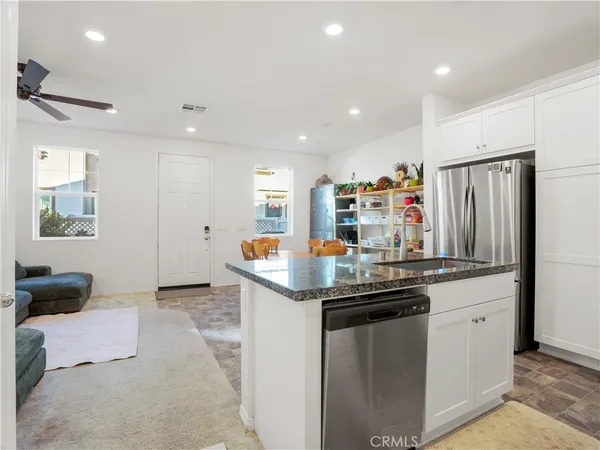 a kitchen with stainless steel appliances granite countertop a sink and a refrigerator