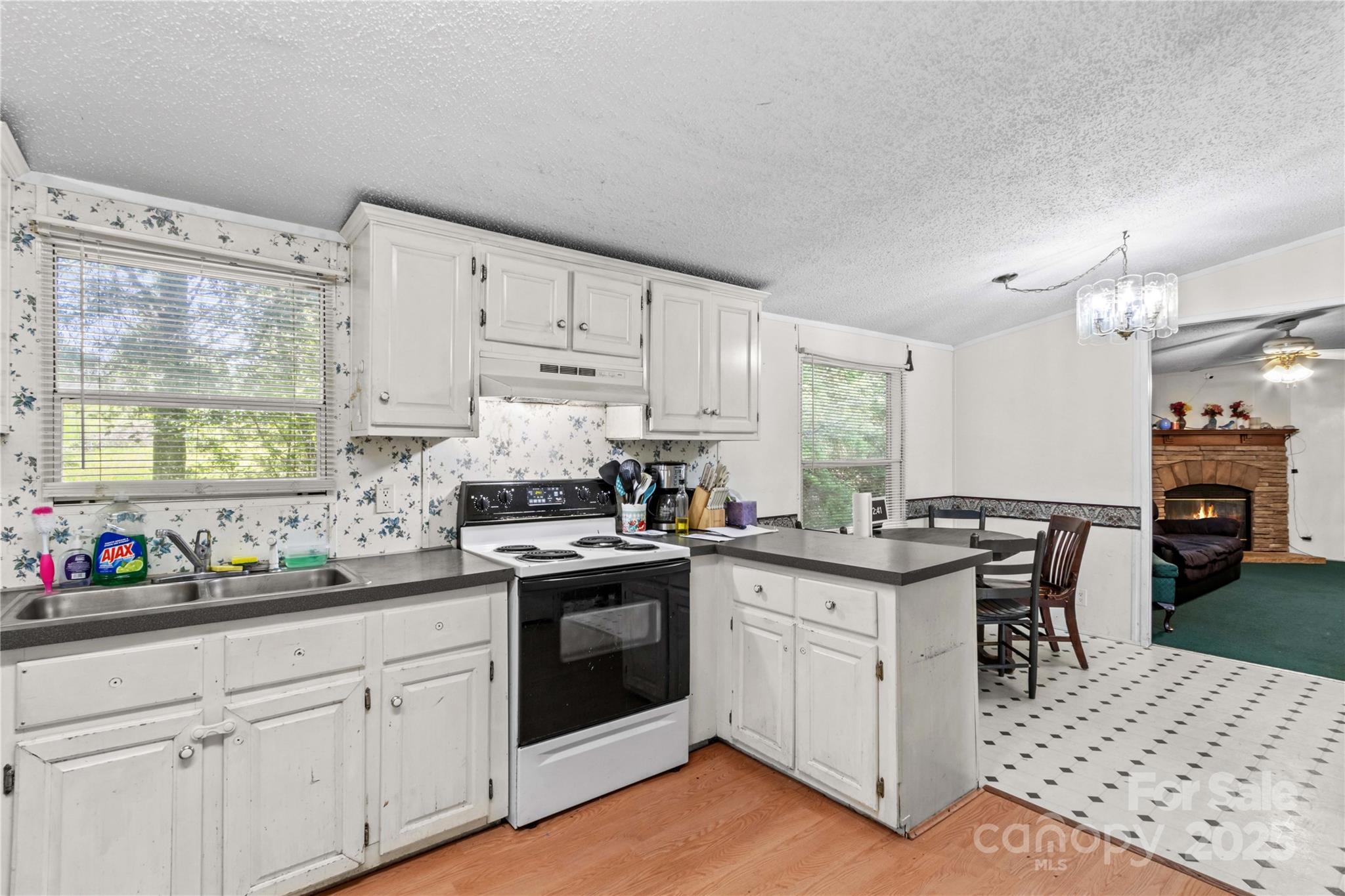 160 Ranchway Mocksville, NC 27028 - Photo 6 of 24 a kitchen with stainless steel appliances granite countertop a stove a sink dishwasher and white cabinets with wooden floor