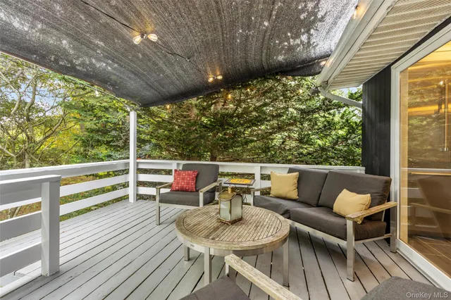 a balcony with wooden floor and outdoor seating