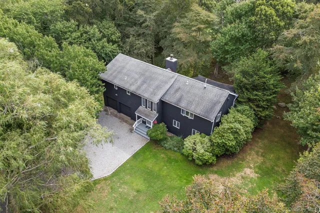 an aerial view of a house with a yard and large trees