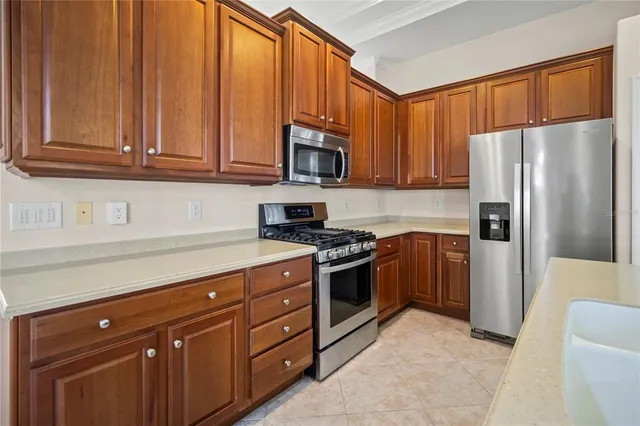 a kitchen with stainless steel appliances granite countertop a refrigerator a stove a sink and dishwasher