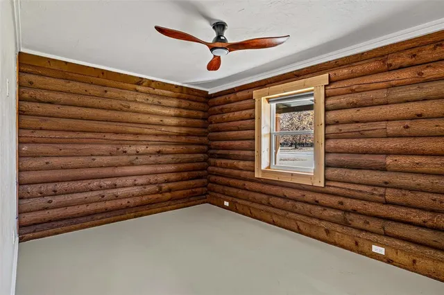 an empty room with closet and fan