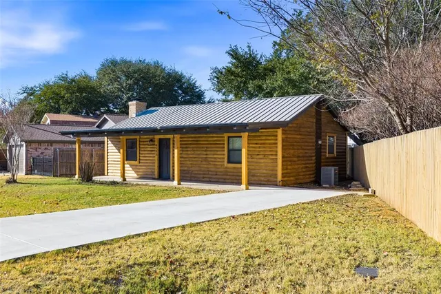 a front view of a house with a garden and trees