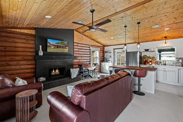 a living room with furniture a fireplace and a flat screen tv
