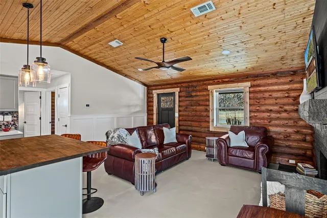 a living room with furniture a fireplace and a chandelier