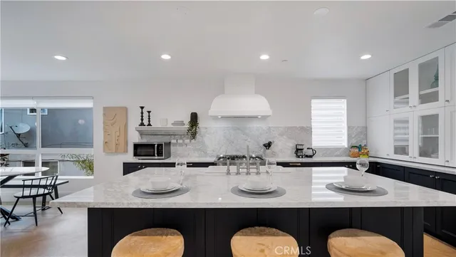 a kitchen with granite countertop a sink and white cabinets
