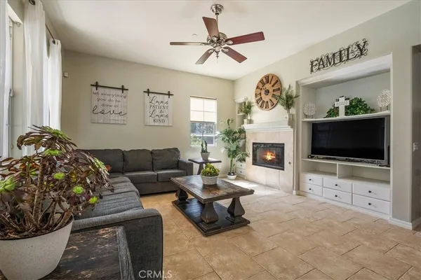 a living room with furniture a flat screen tv and a fireplace