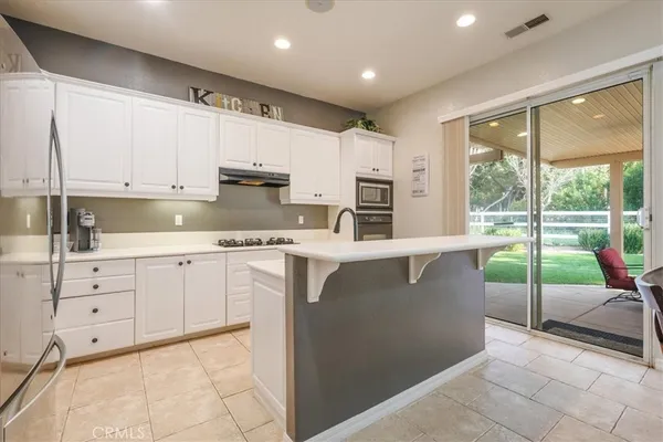 a kitchen with kitchen island white cabinets and white appliances