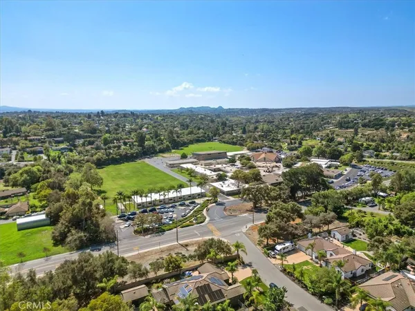 an aerial view of residential houses with outdoor space and ocean view