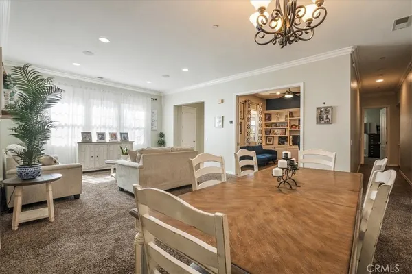 a living room with furniture a dining table and chairs with wooden floor