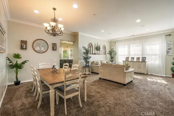 a dining room with furniture a chandelier and wooden floor