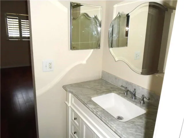 a bathroom with a granite countertop sink and a mirror