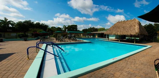 a view of a house with swimming pool and sitting area