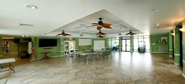 a view of a dining hall with lots of tables a large window and furniture