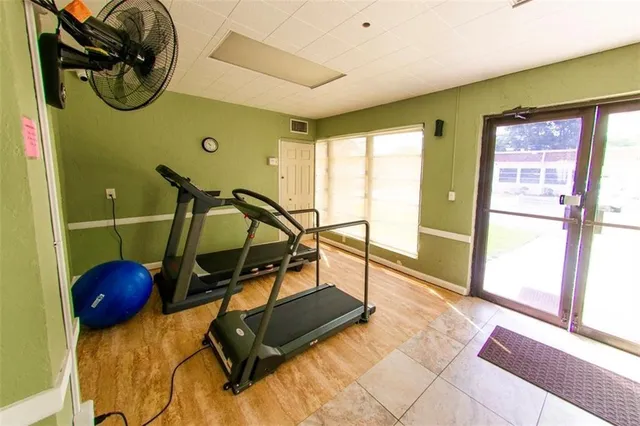 a view of a patio with table and chairs potted plants and large tree