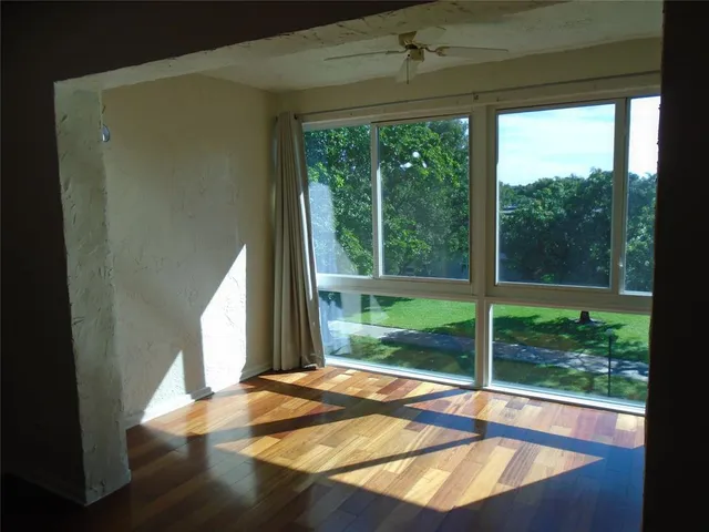a view of a bedroom with a bed and wooden floor