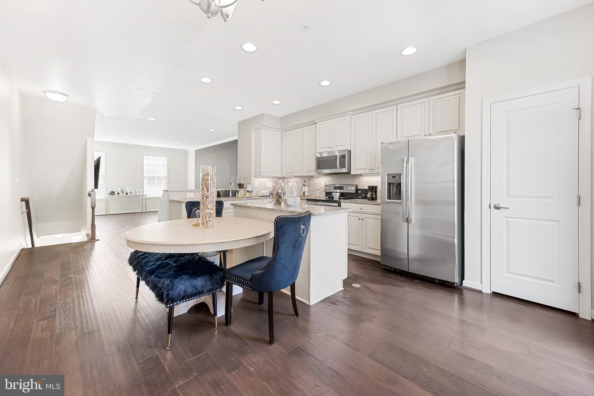 810 South Macon Street Baltimore, MD 21224 - Photo 16 of 31 a kitchen with stainless steel appliances a dining table chairs refrigerator sink and cabinets