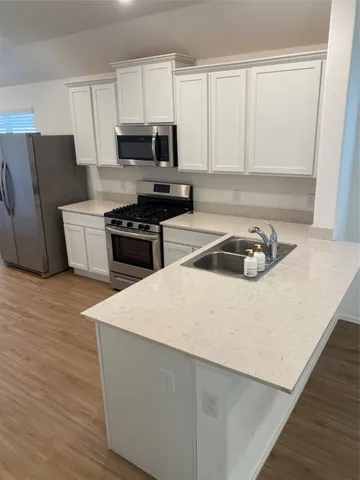 a kitchen with granite countertop a stove a sink and a microwave