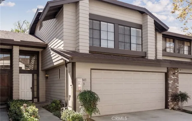 a front view of a house with plants