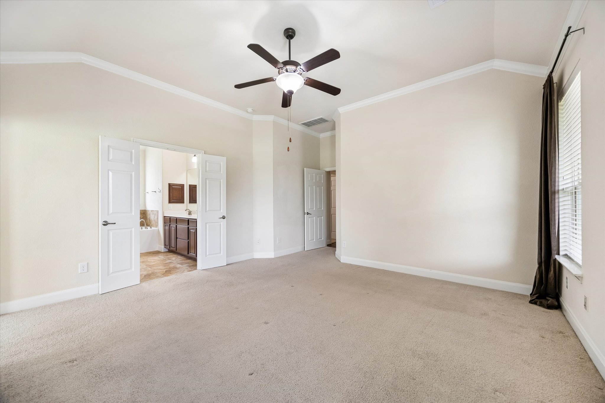 2214 Wembley Way Rosenberg, TX 77471 - Photo 26 of 35 Spacious interior featuring vaulted ceilings with crown molding, a ceiling fan with integrated lighting, and carpet flooring