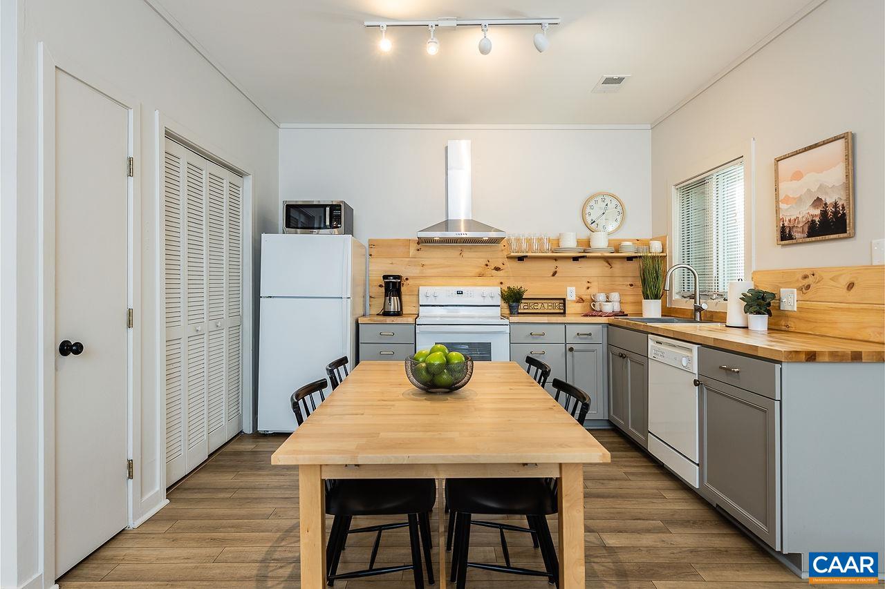 449 3 Ridges Wintergreen, VA 22967 - Photo 7 of 21 a kitchen with stainless steel appliances granite countertop wooden floor and white cabinets