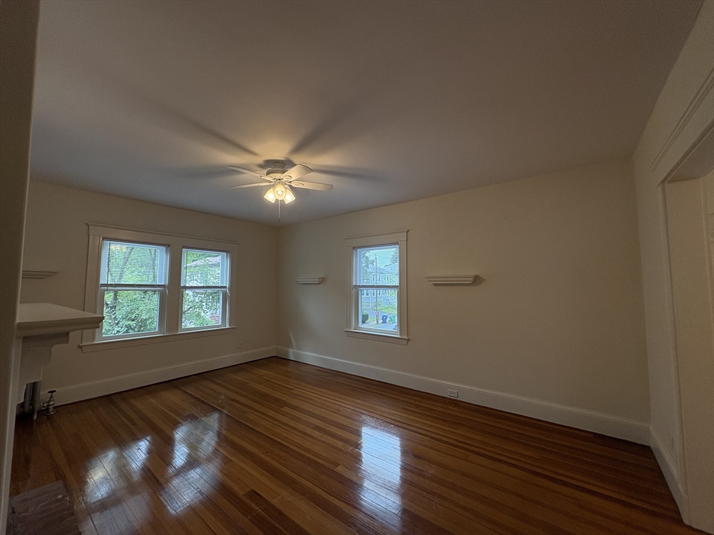 97 Warwick Road, Unit 97 Newton, MA 02465 - Photo 16 of 24 a view of an empty room with wooden floor and a window