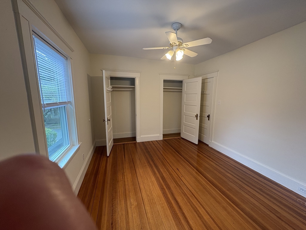 97 Warwick Road, Unit 97 Newton, MA 02465 - Photo 2 of 24 a view of an empty room with wooden floor and a window