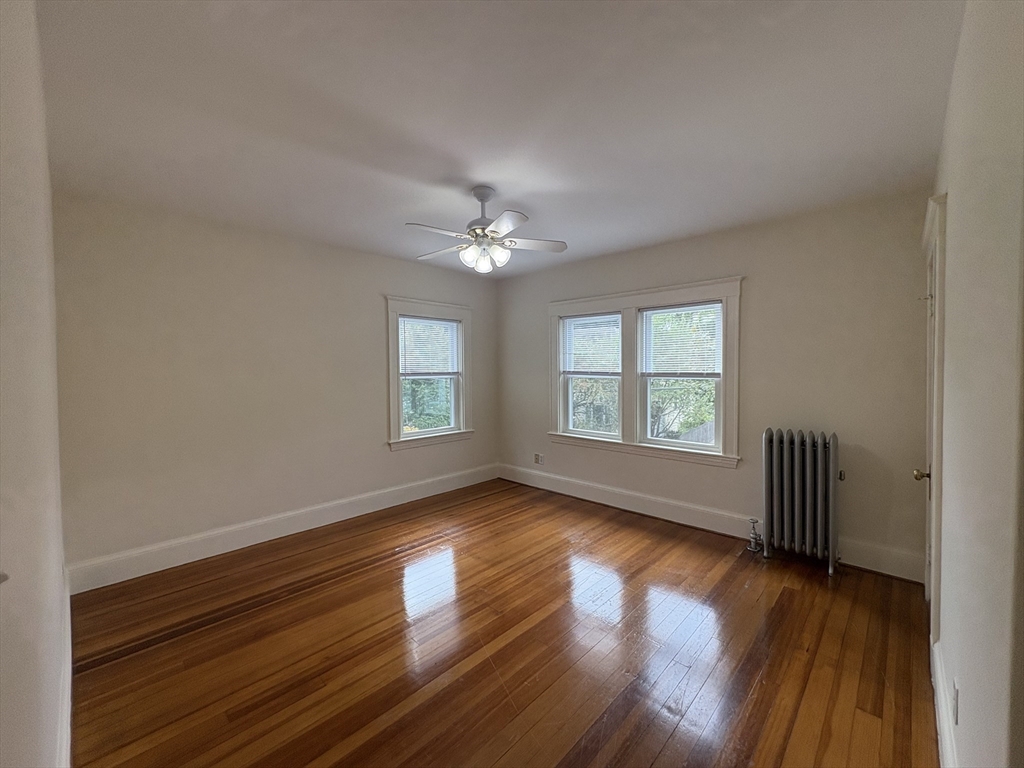 97 Warwick Road, Unit 97 Newton, MA 02465 - Photo 3 of 24 a view of an empty room with wooden floor and a window