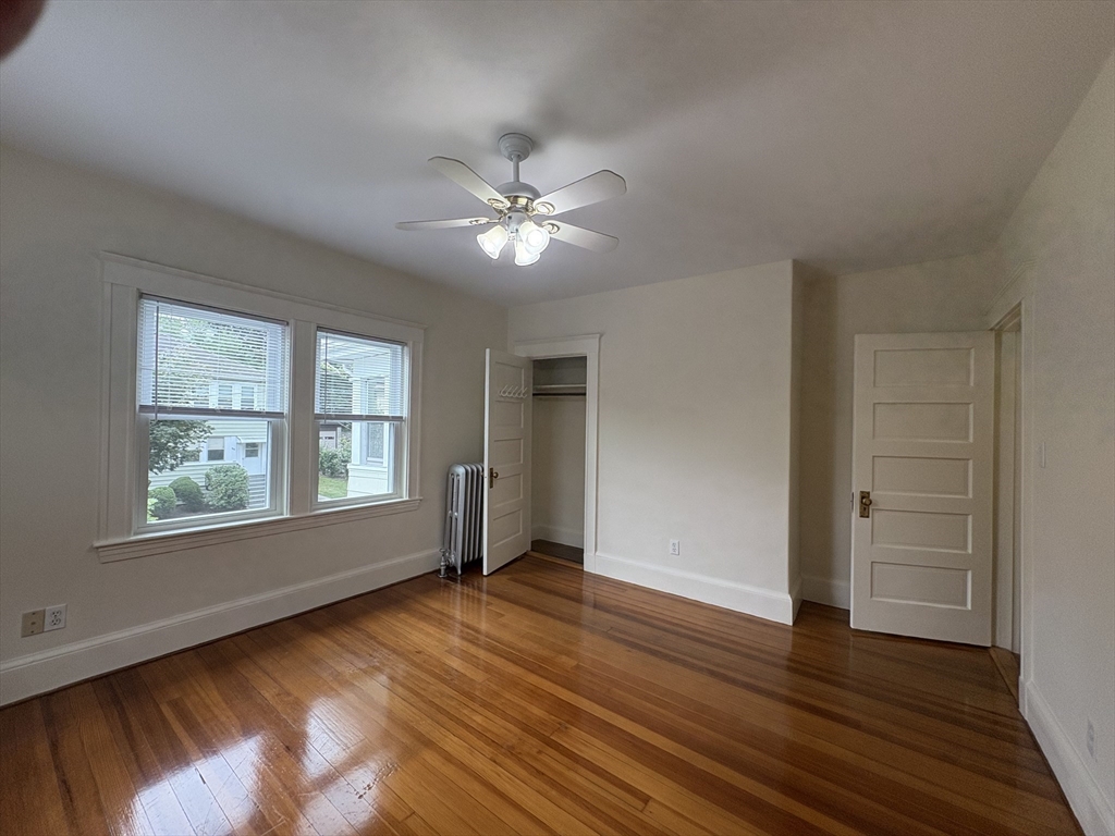 97 Warwick Road, Unit 97 Newton, MA 02465 - Photo 4 of 24 a view of empty room with wooden floor and fan
