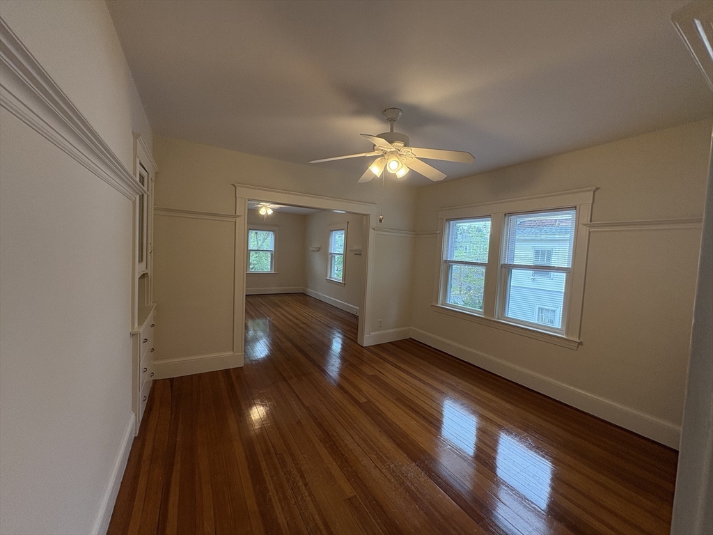 97 Warwick Road, Unit 97 Newton, MA 02465 - Photo 8 of 24 a view of an empty room with window and wooden floor