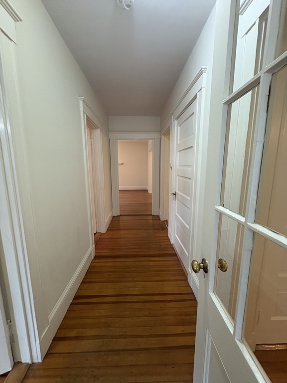 97 Warwick Road, Unit 97 Newton, MA 02465 - Photo 10 of 24 a hallway with wooden floor and staircase