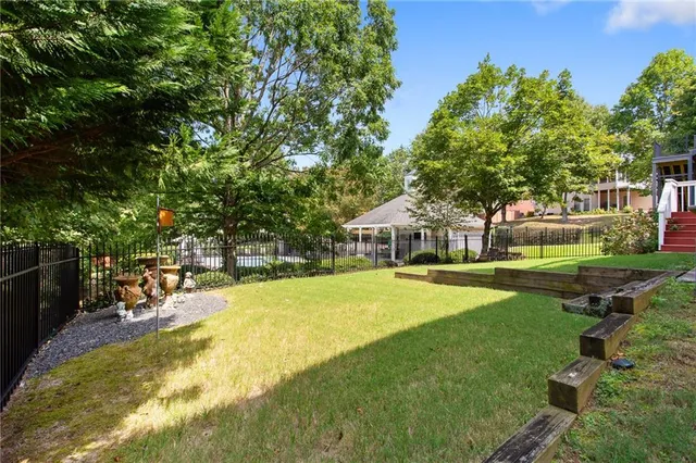 a view of a swimming pool with lawn chairs and plants