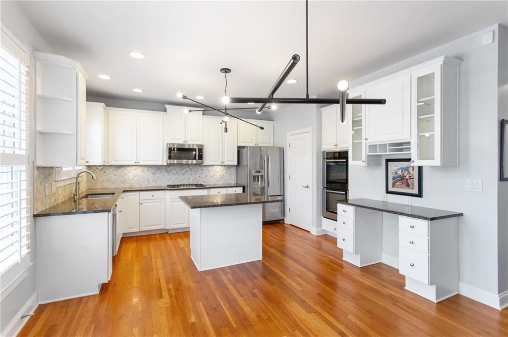 3522 Ivy Manor Road Southeast Smyrna, GA 30080 - Photo 8 of 47 a large kitchen with stainless steel appliances kitchen island a large counter space and wooden floor