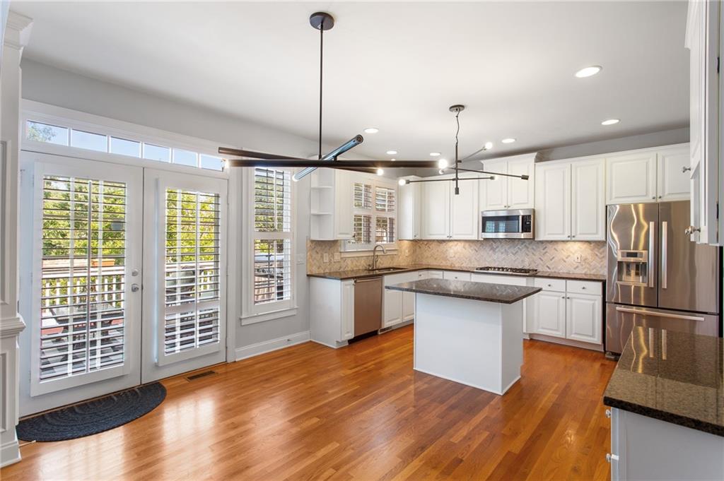3522 Ivy Manor Road Southeast Smyrna, GA 30080 - Photo 9 of 47 a kitchen with stainless steel appliances granite countertop a refrigerator a oven a island and a wooden floors