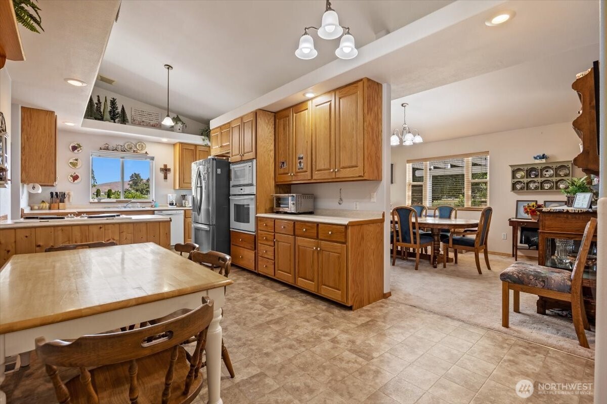 157209 West North River Road Prosser, WA 99350 - Photo 7 of 40 a kitchen with stainless steel appliances kitchen island granite countertop a table chairs sink and cabinets