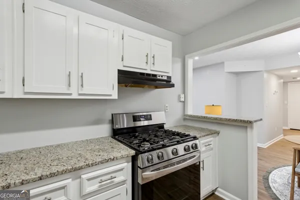 a kitchen with granite countertop white cabinets and appliances
