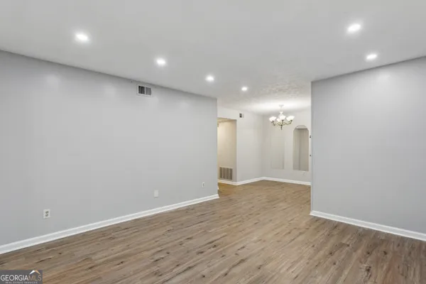 a view of an empty room with wooden floor