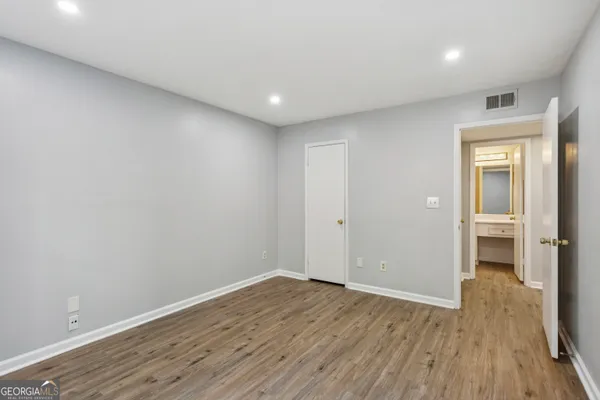a view of a room with wooden floor and a bathroom