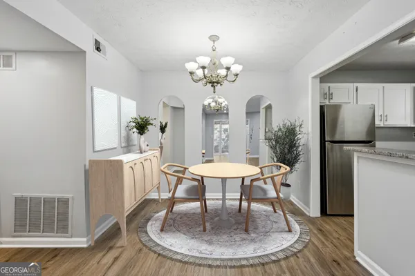 a dining room with furniture a chandelier and wooden floor