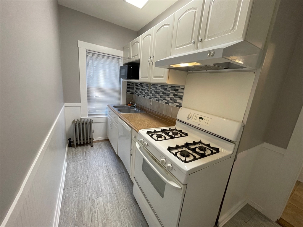 46 Lane Street, Unit 1 Lowell, MA 01851 - Photo 13 of 19 a kitchen with a stove and a refrigerator