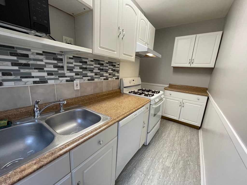 46 Lane Street, Unit 1 Lowell, MA 01851 - Photo 14 of 19 a kitchen with a sink a stove and cabinets