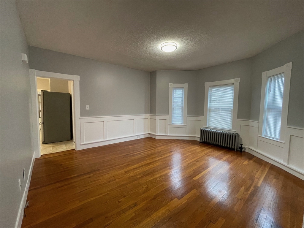 46 Lane Street, Unit 1 Lowell, MA 01851 - Photo 18 of 19 an empty room with wooden floor and windows