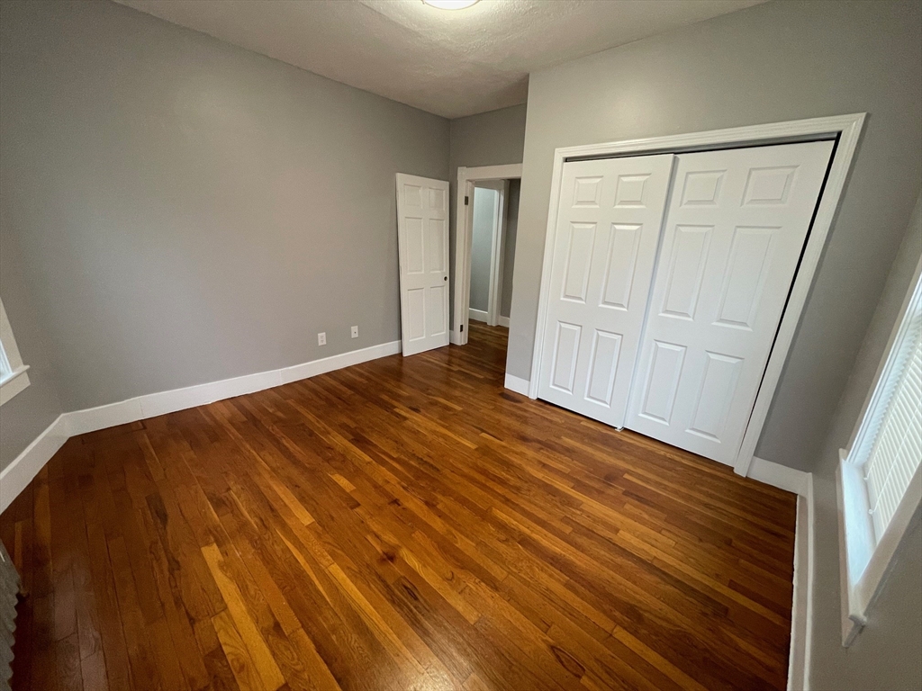 46 Lane Street, Unit 1 Lowell, MA 01851 - Photo 19 of 19 a view of an empty room with wooden floor and a window