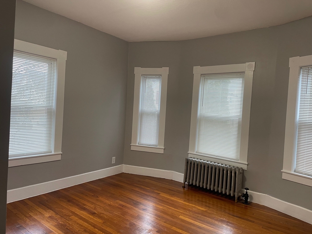 46 Lane Street, Unit 1 Lowell, MA 01851 - Photo 2 of 19 an empty room with wooden floor and windows