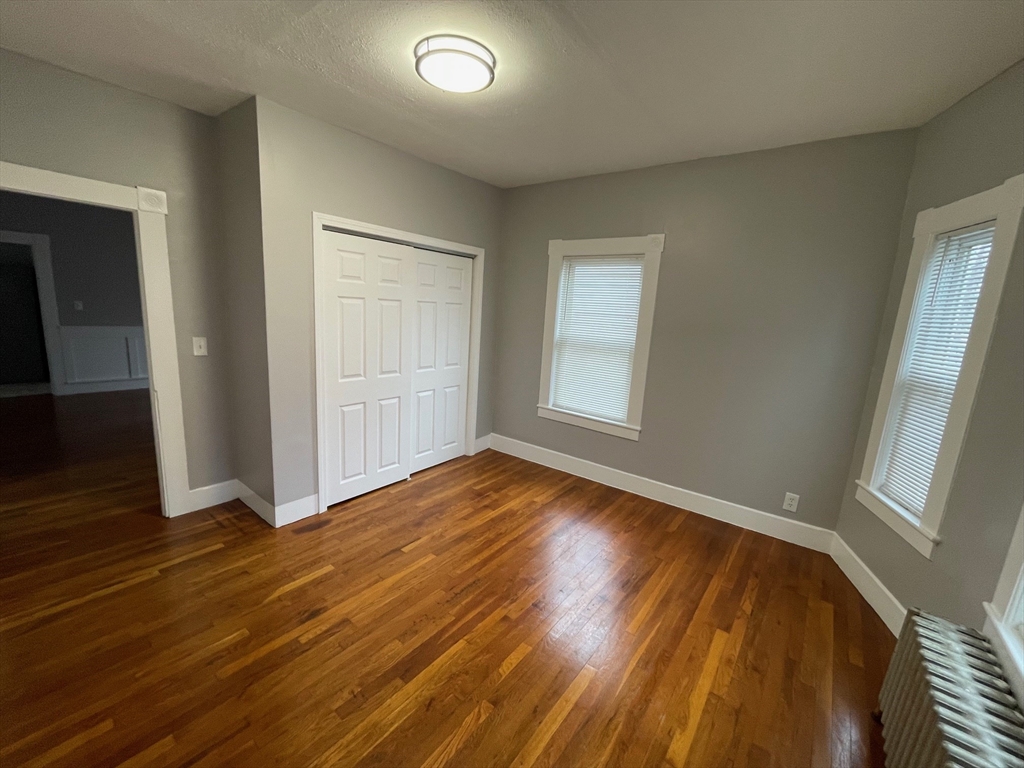 46 Lane Street, Unit 1 Lowell, MA 01851 - Photo 3 of 19 an empty room with wooden floor and windows