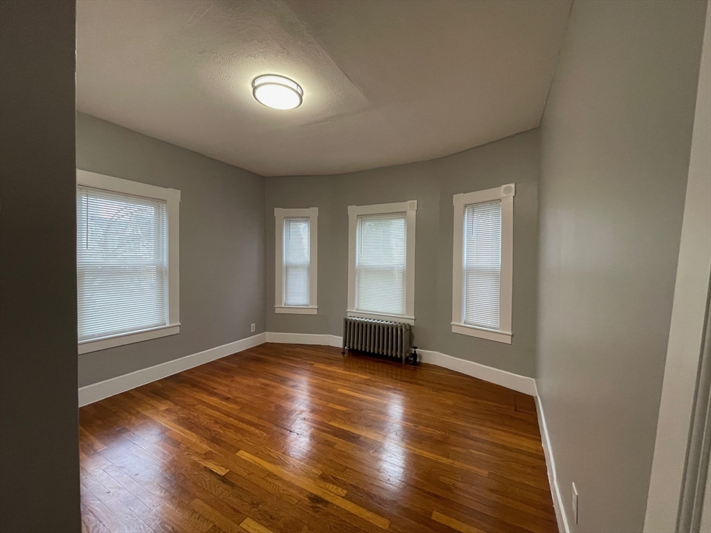 46 Lane Street, Unit 1 Lowell, MA 01851 - Photo 4 of 19 an empty room with wooden floor and windows
